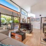 Wohnzimmer mit 65 Zoll Flachbild TV und viel Licht durch große Fenster